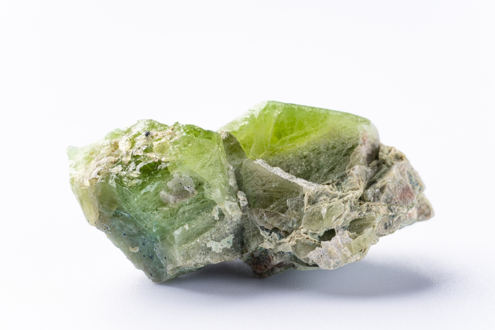 A raw piece of Peridot on a white background