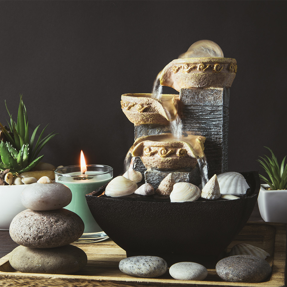 Pebbles, plants, and fountain arranged using feng shui principles.