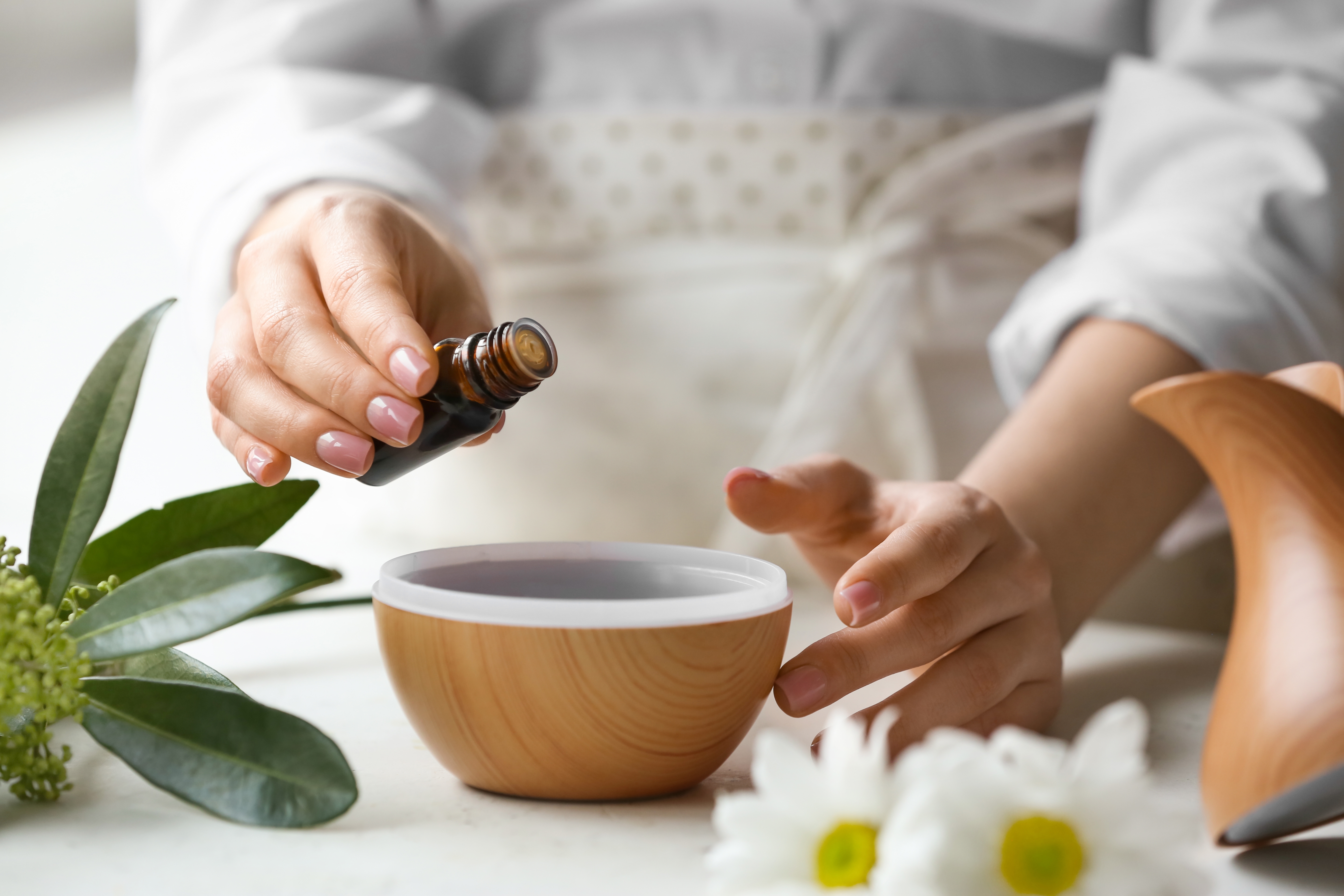 Person filling a diffuser with essential oils