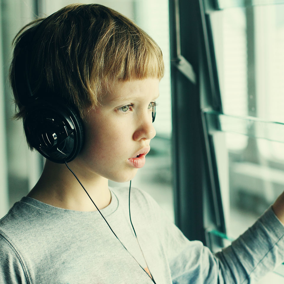 An autistic boy wearing headphones.