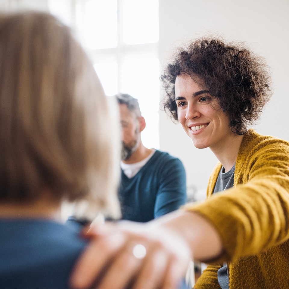 People in sitting in a circle during group therapy, supporting each other