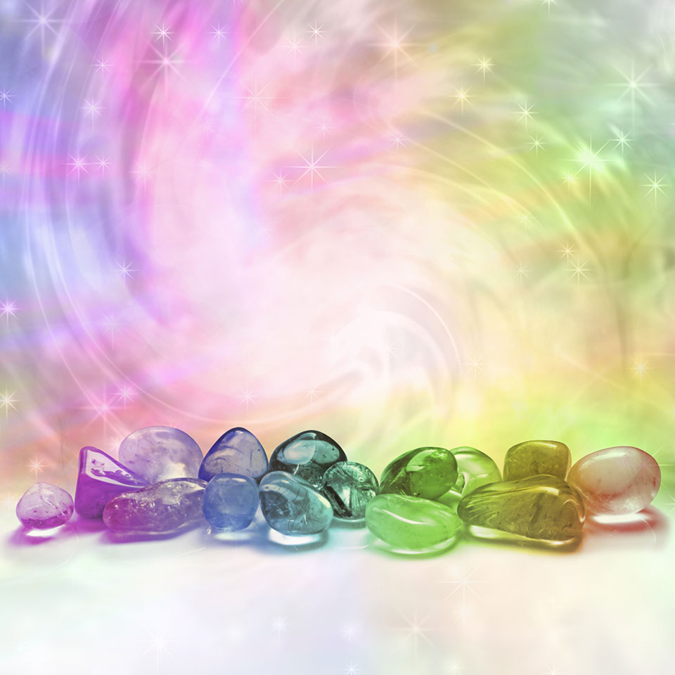 Advanced Crystal Healing - Various colourful crystals in front of a colourful, swirling vortex of light