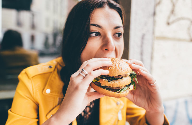 Woman eating a burger outside