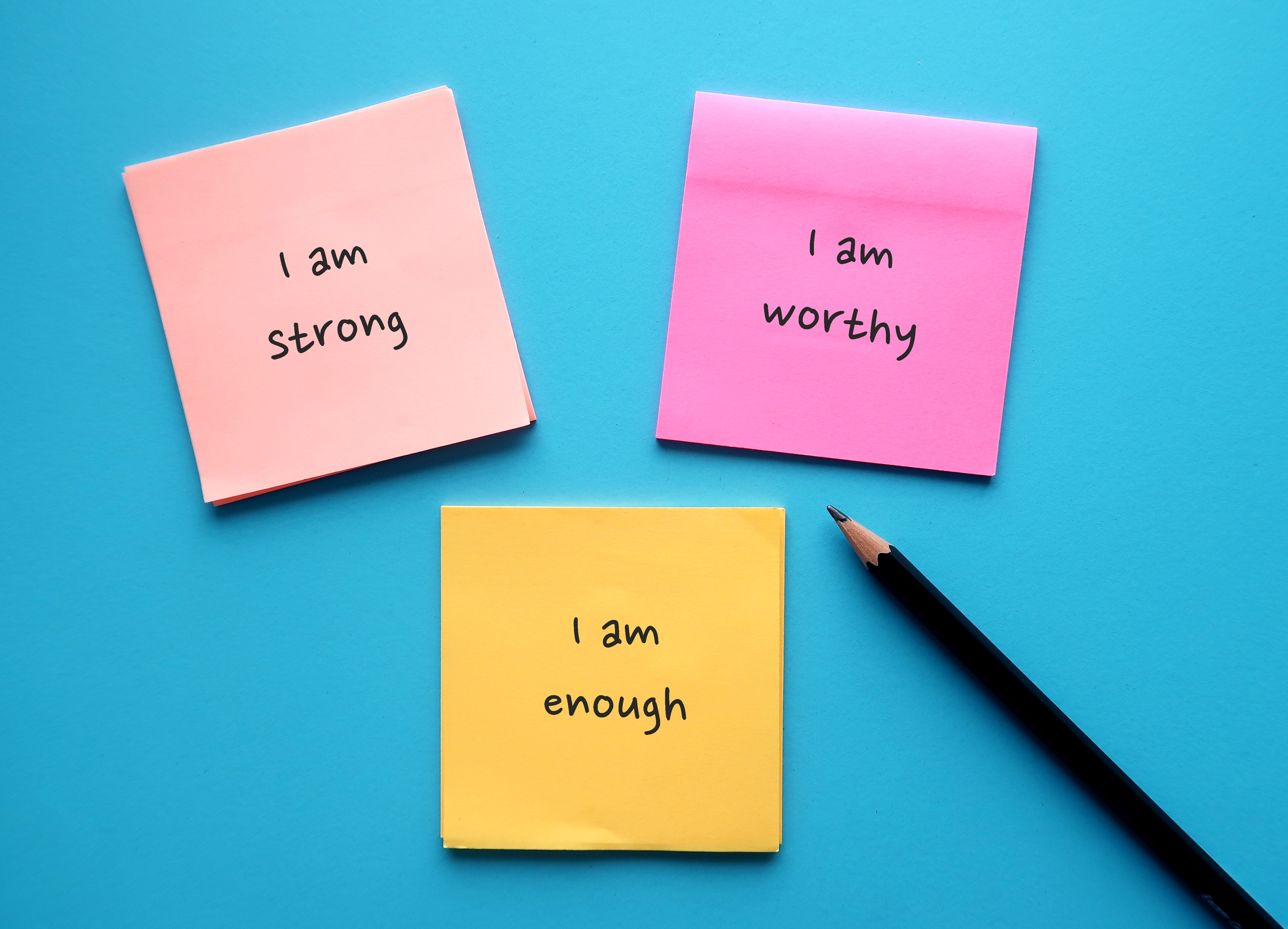 Three sticky notes with the following written on; 'I am strong', 'I am worthy', 'I am enough'