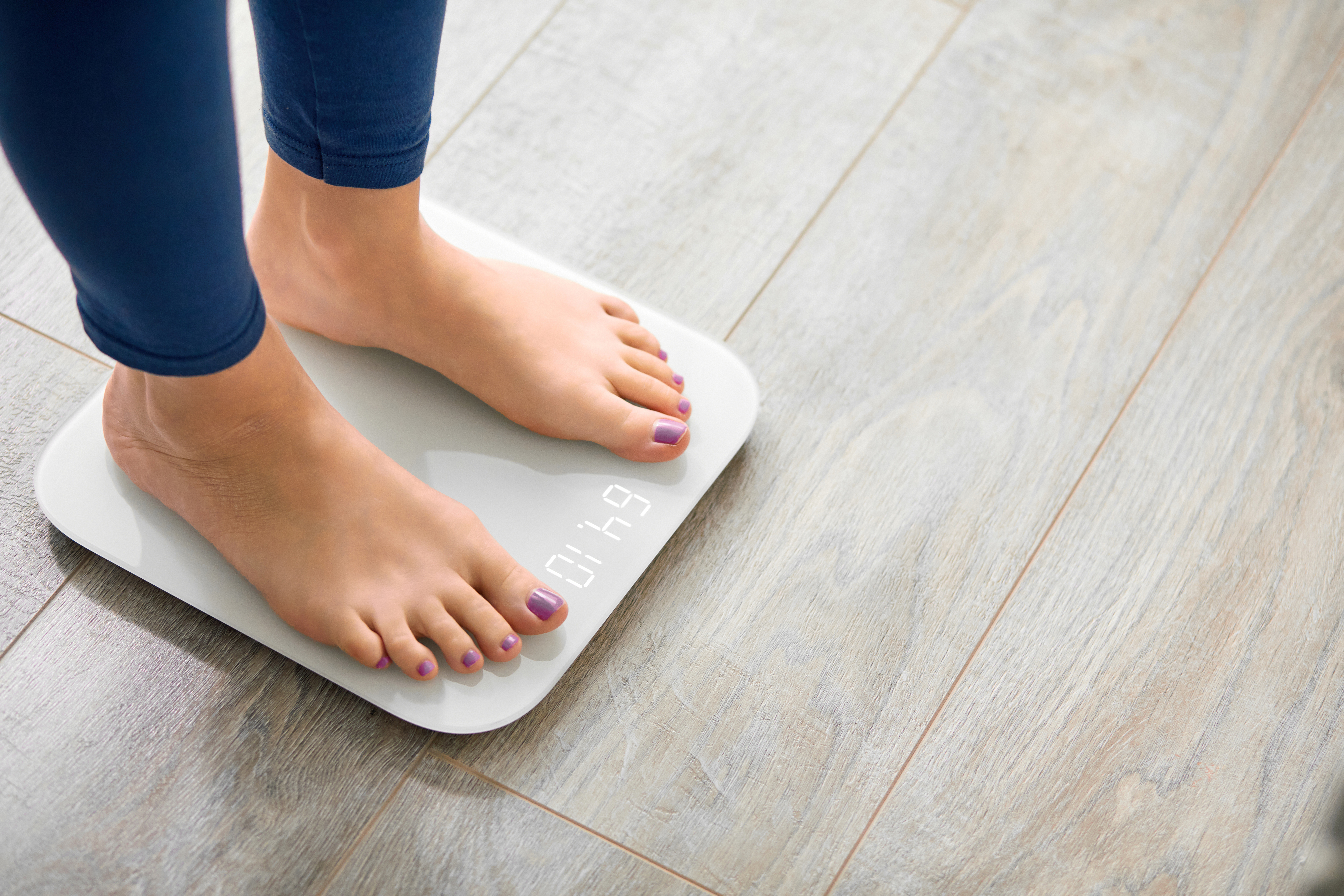Woman's feet standing on scales