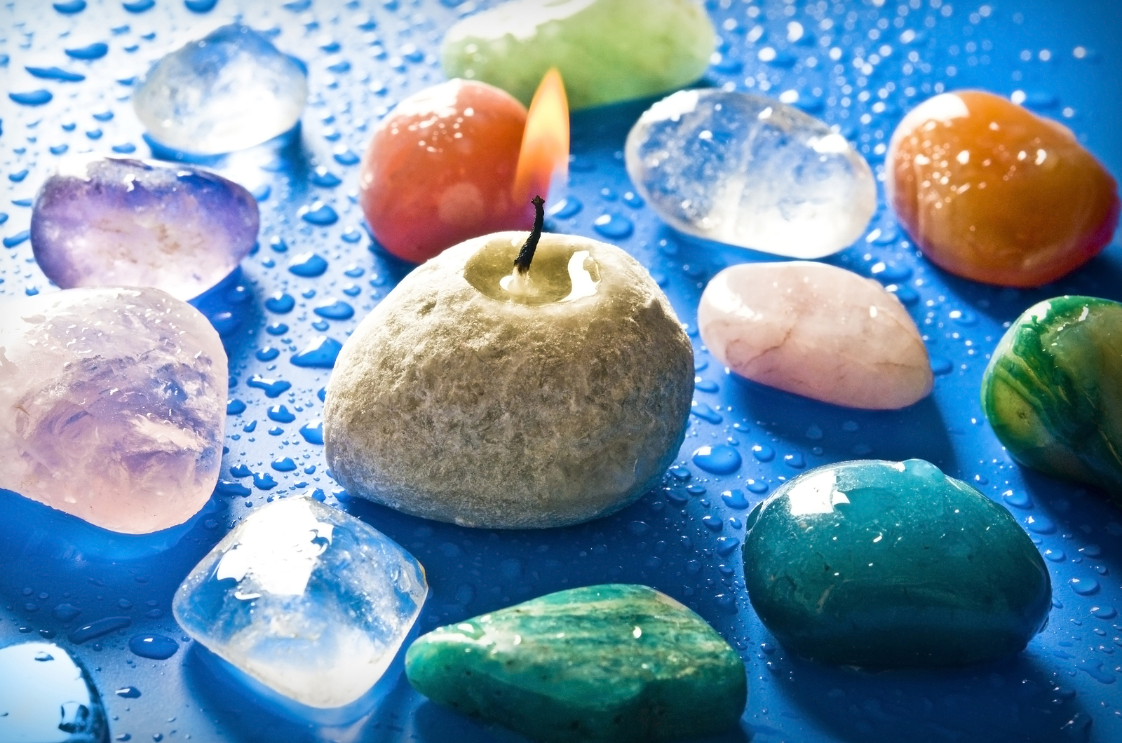 A selection of crystals around a stone candle