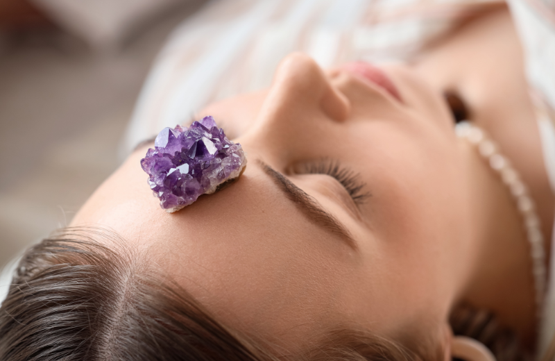 Image of an amethyst crystal on someones head.