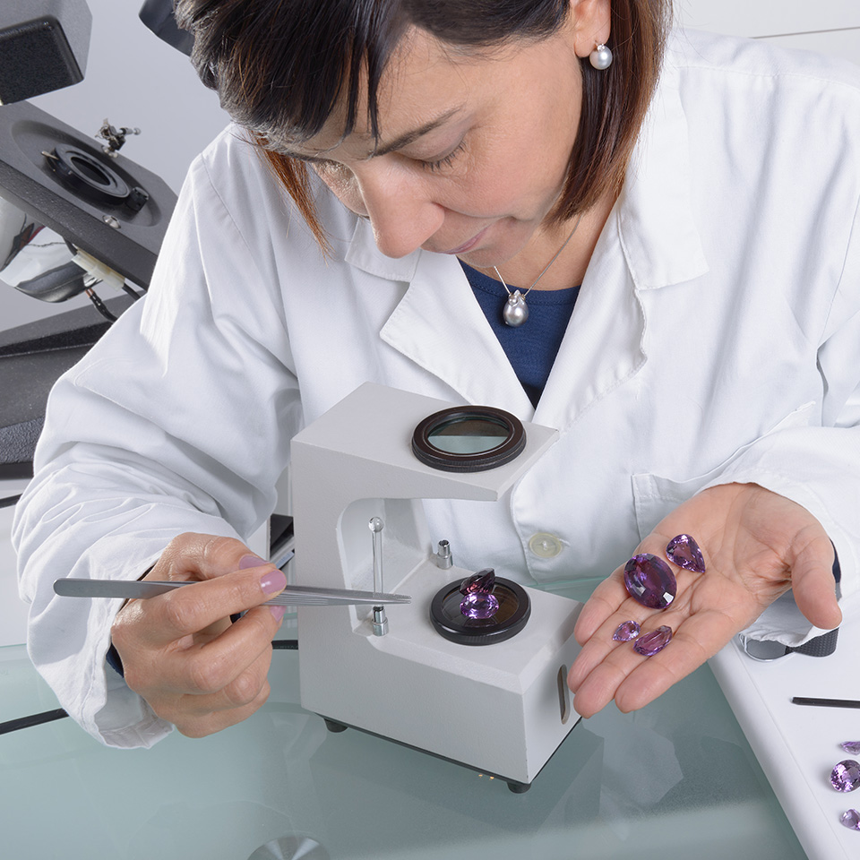 A gemologist in a laboratory working on precious stones