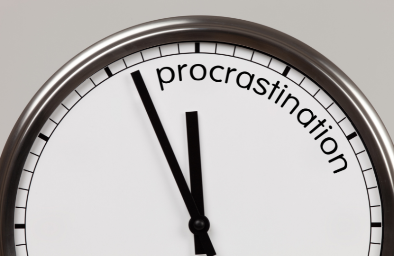 Image of a clock saying 'procrastination.'