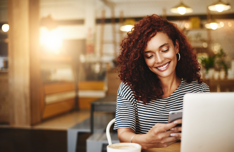 Image of a woman smiling at her phone.