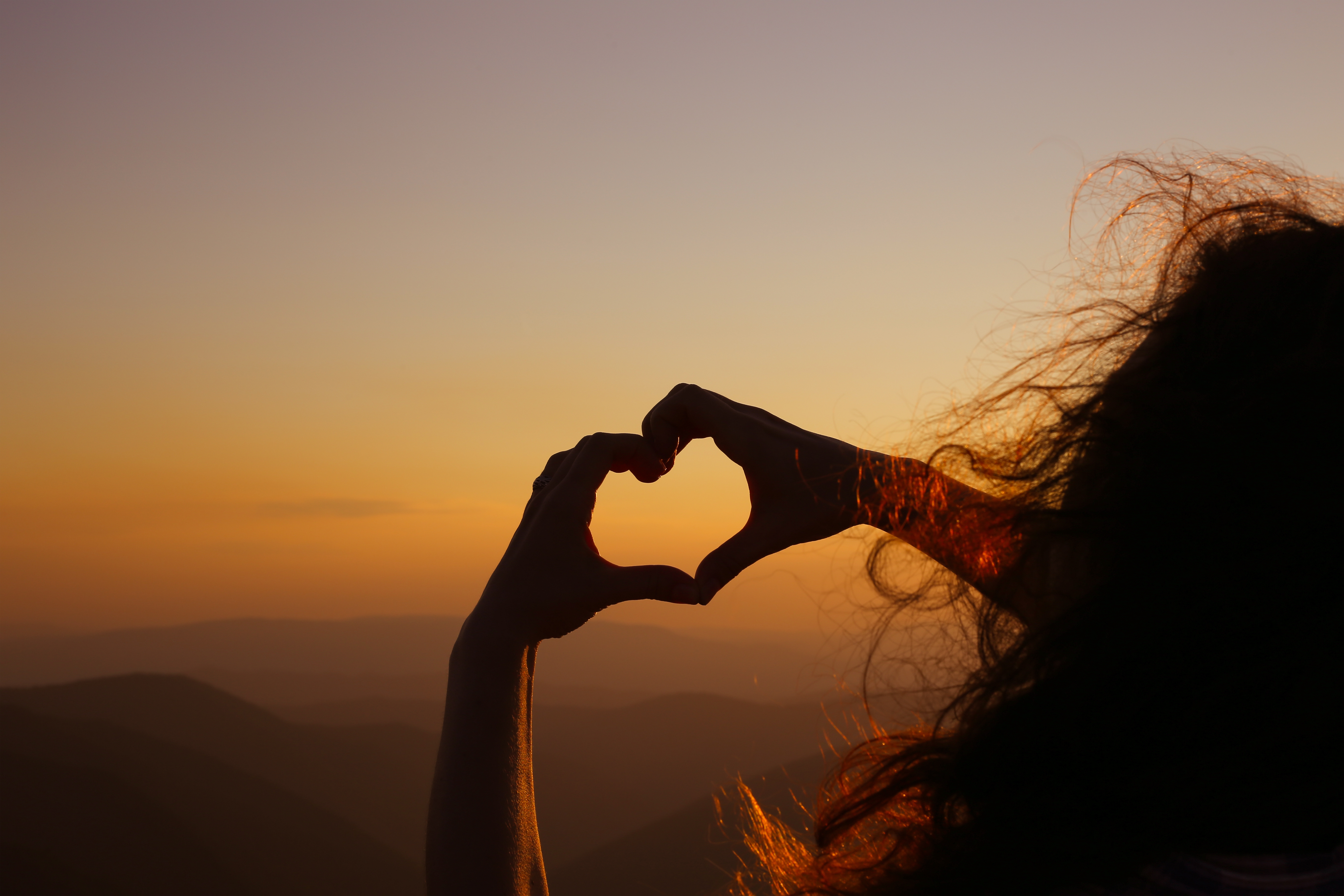 Two hands creating a love heart