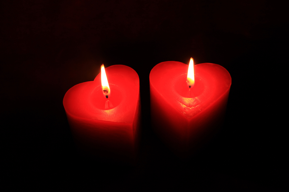 Two heart shaped red candles lit