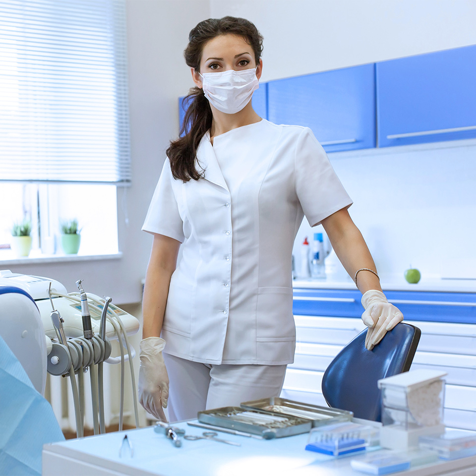 Portrait picture of a dentist wearing a mask in her dental surgery