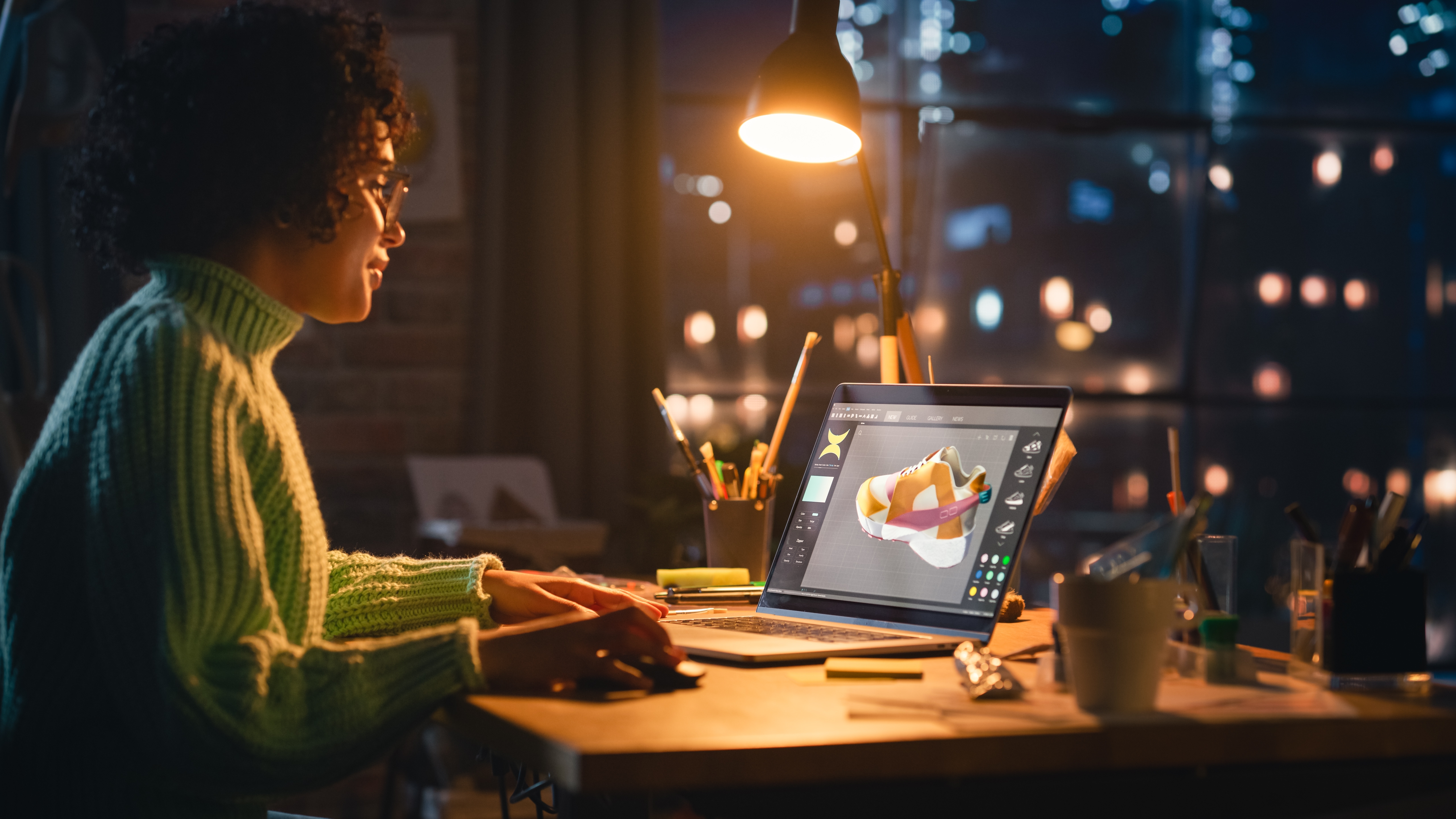 Female graphic designer working on laptop at night