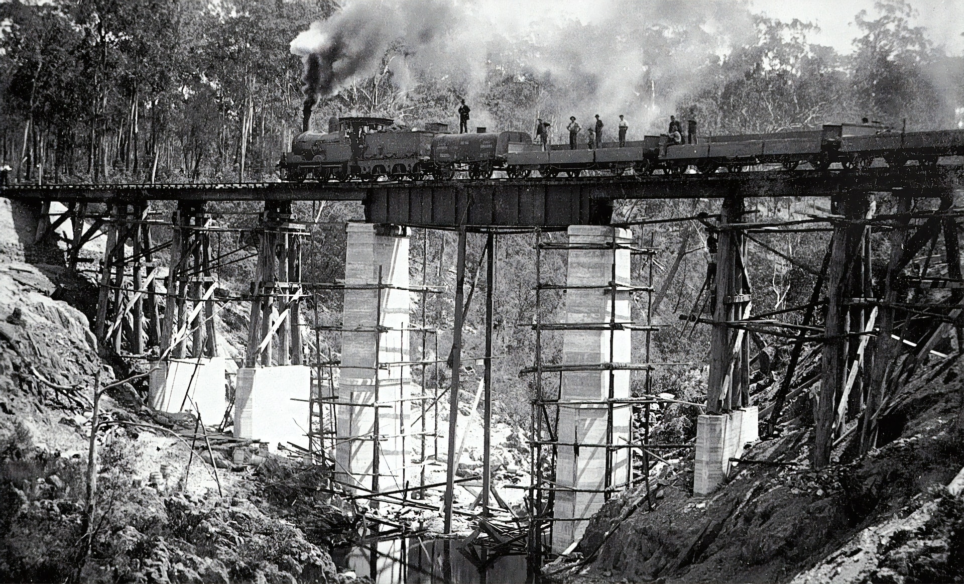A steam locomotive going over a bridge.