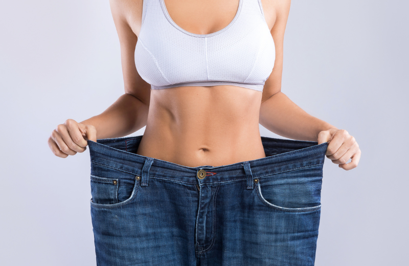 woman wearing large trousers showing weight loss