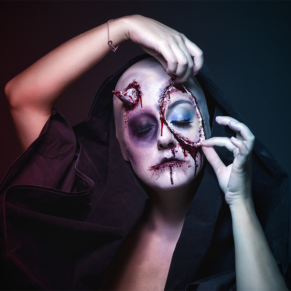 Woman with demon makeup applied to the face and head