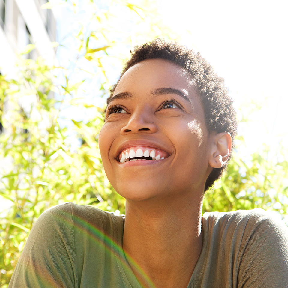 Close up portrait of a young woman smiling outdoors