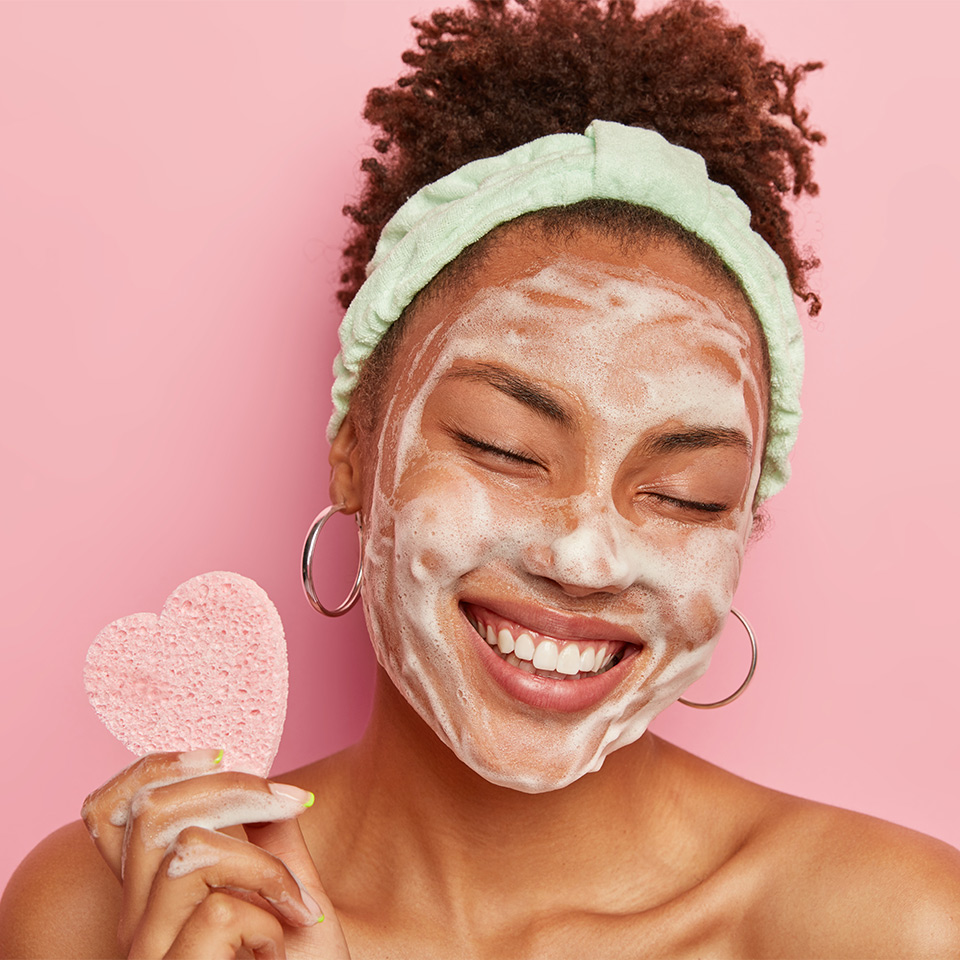 A woman cleansing her face with foam