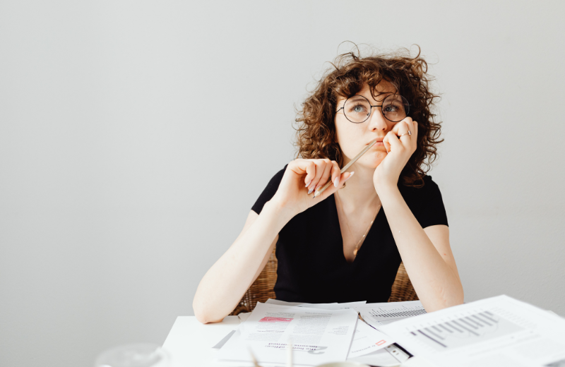 A lady thinking at a desk
