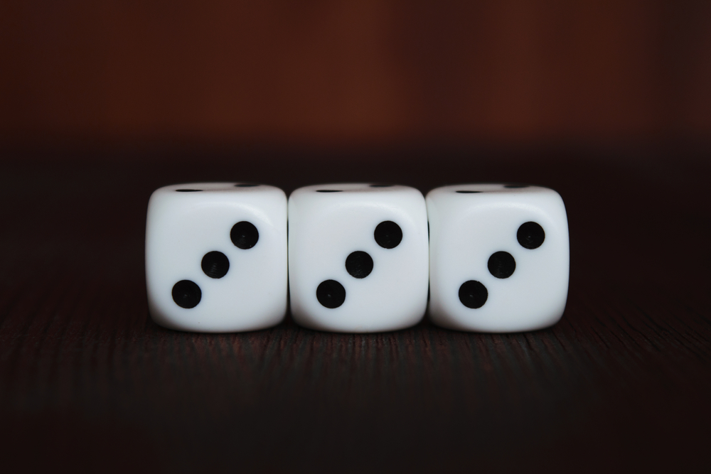 Three dice all showing the number three
