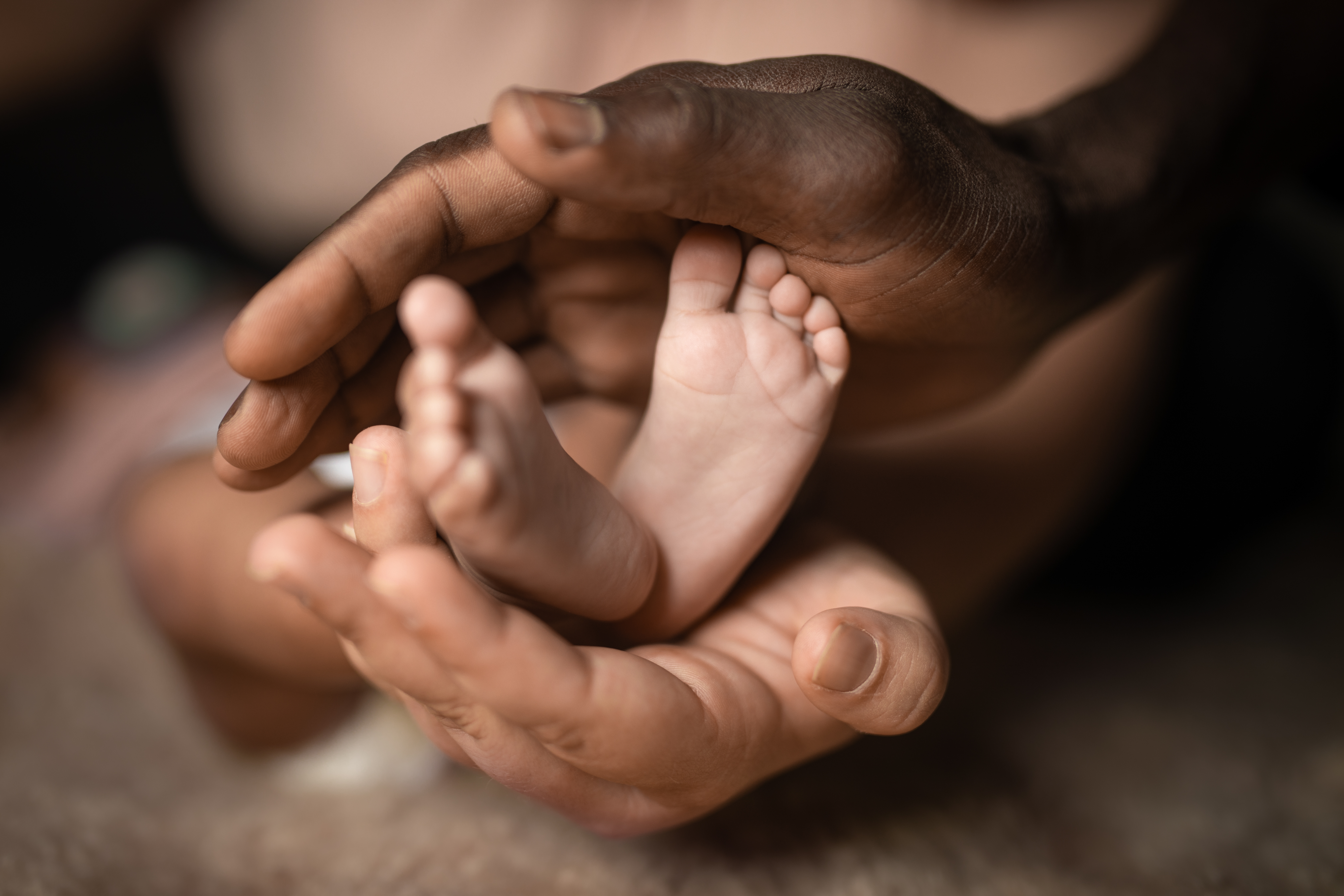 Parents hands holding their baby's feet