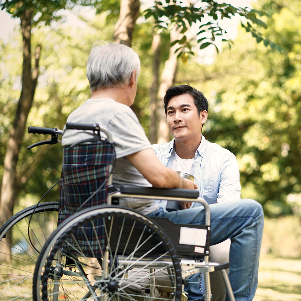 Death doula talking with an older man in a wheelchair