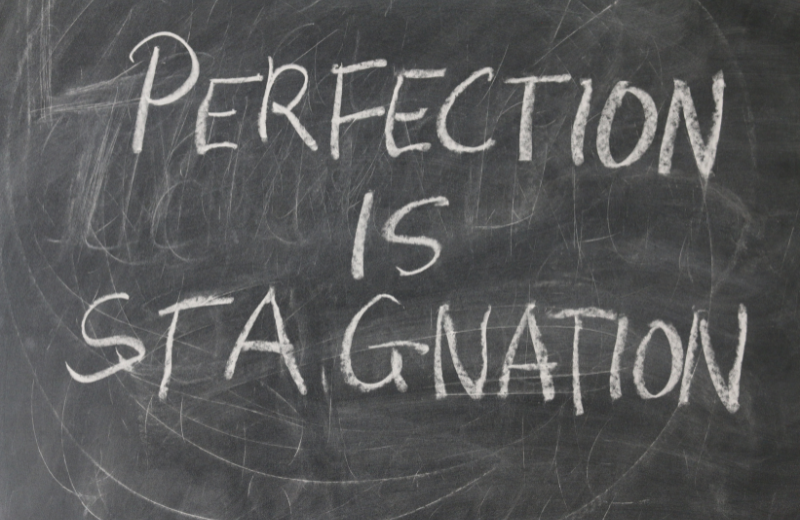 Image of a sign that says 'perfection is stagnation.'