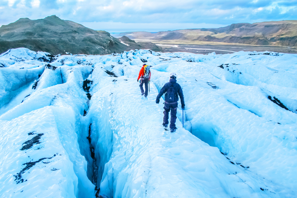 Hiking on the ice blue glacier in Iceland.