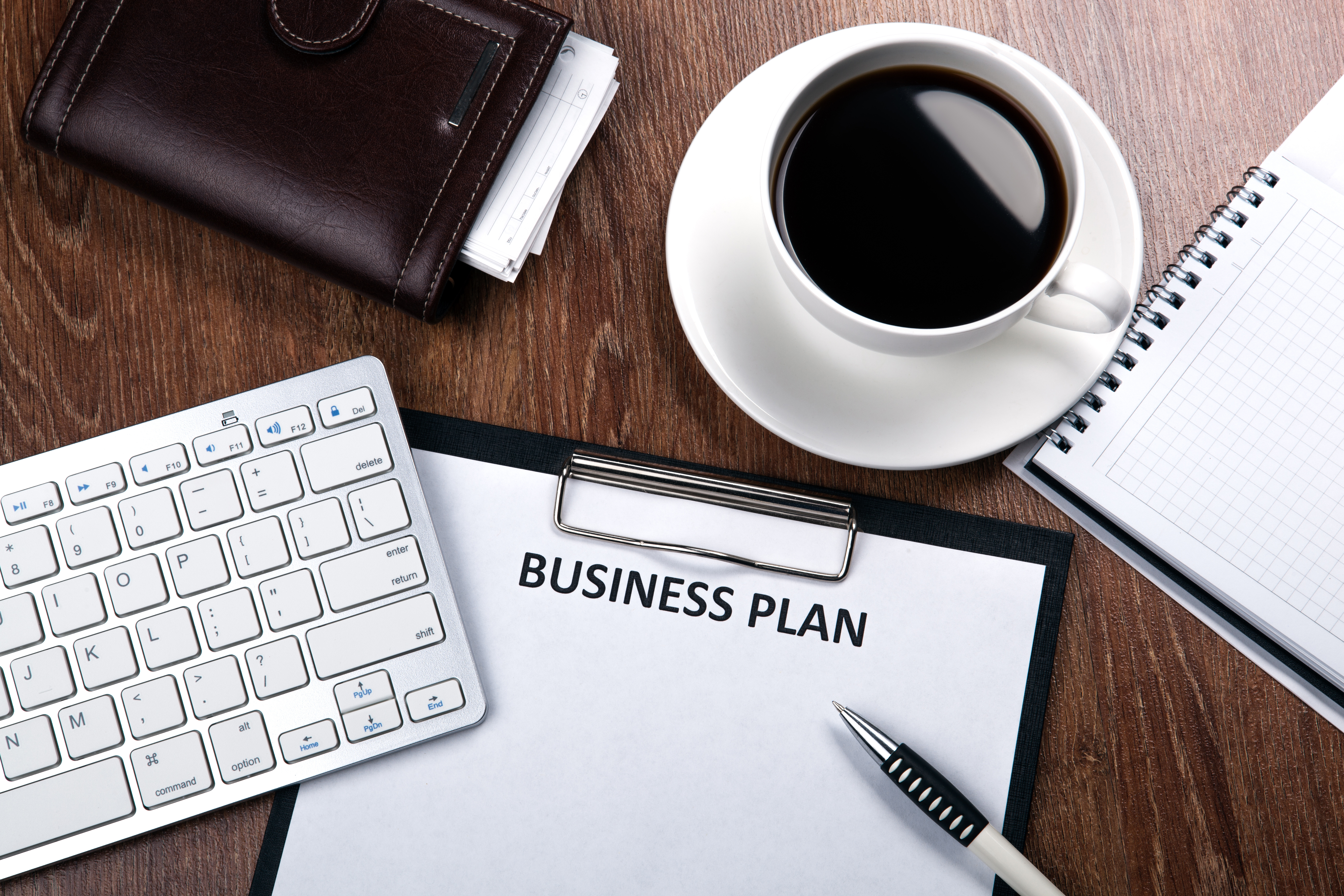 Business plan image flat lay with notebook and pen, coffee and keyboard