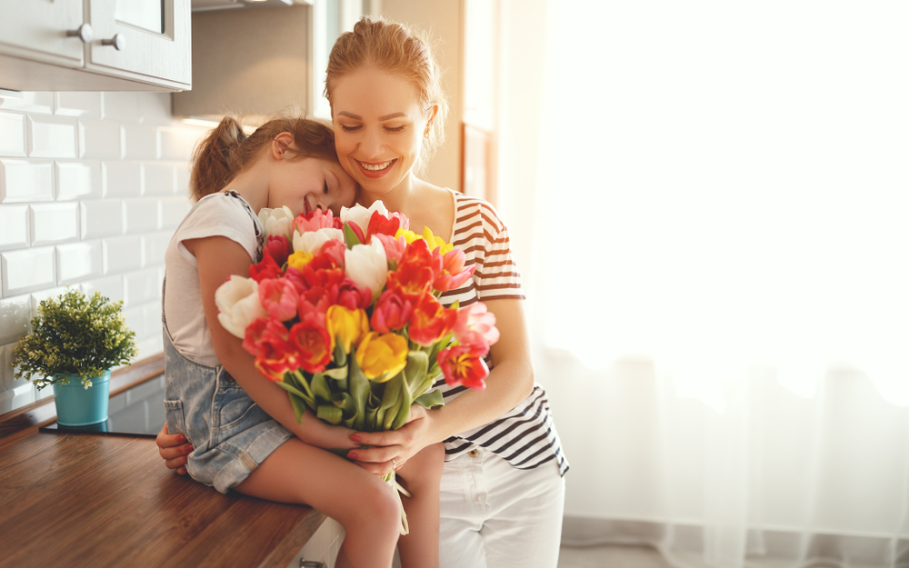 A mother and her daughter with a bunch of flowers