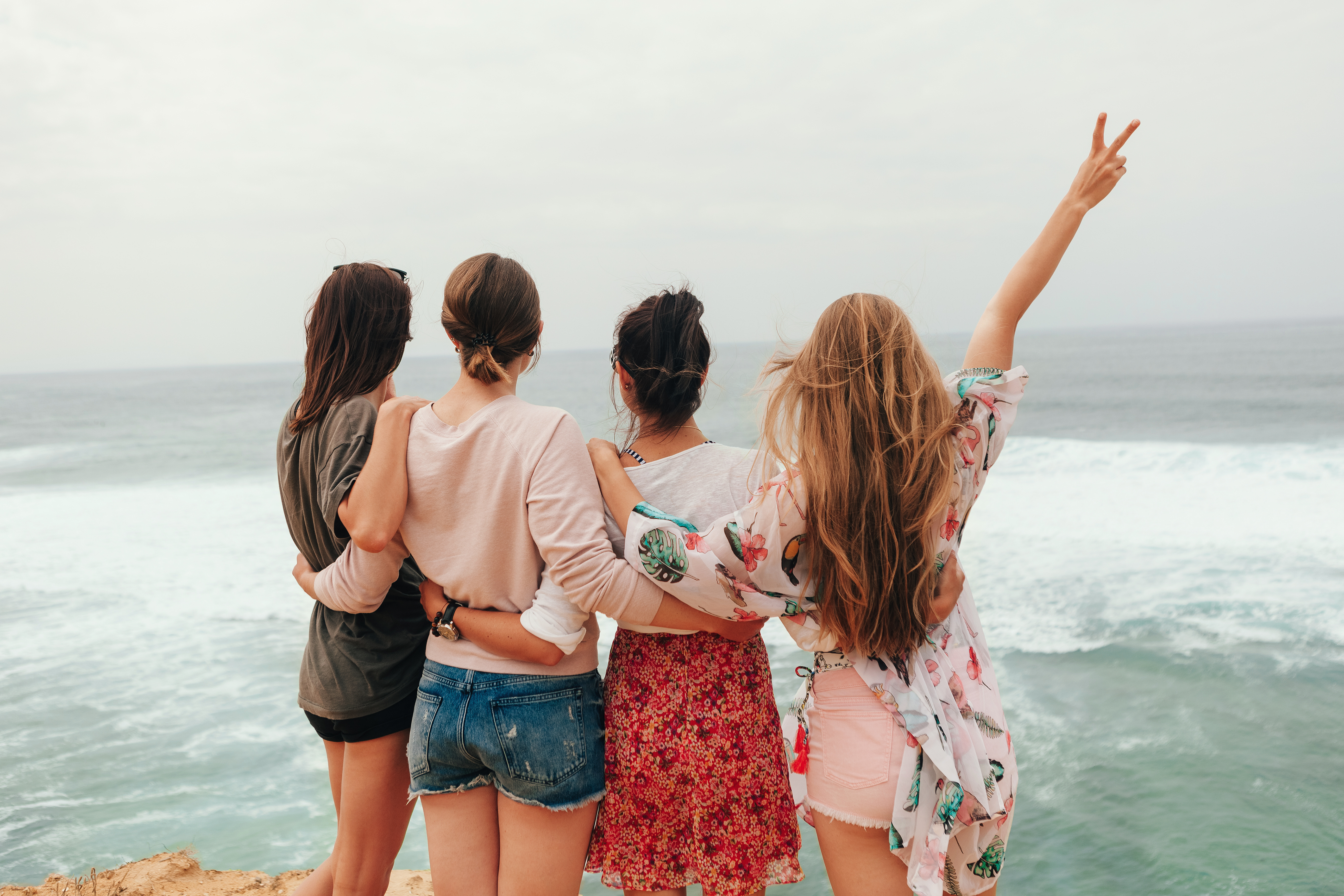 Women embracing by the ocean, female empowerment