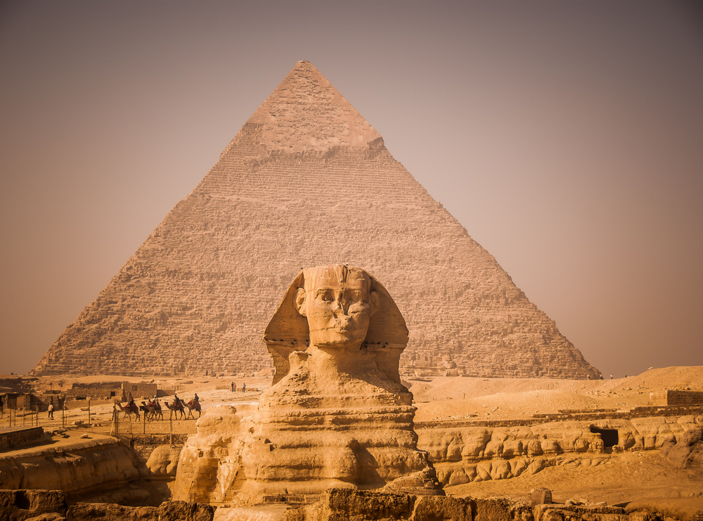 A Sphinx statue in front of a pyramid