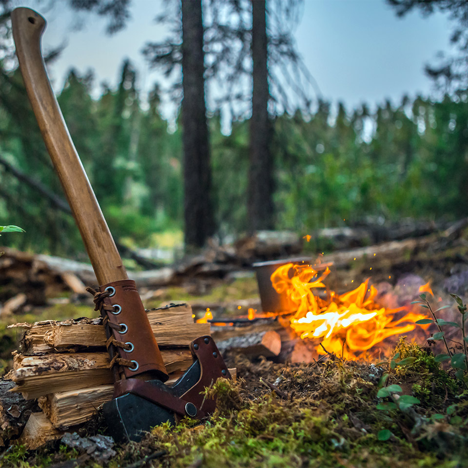 A bushcraft survival scene of an axe and fire in a forest