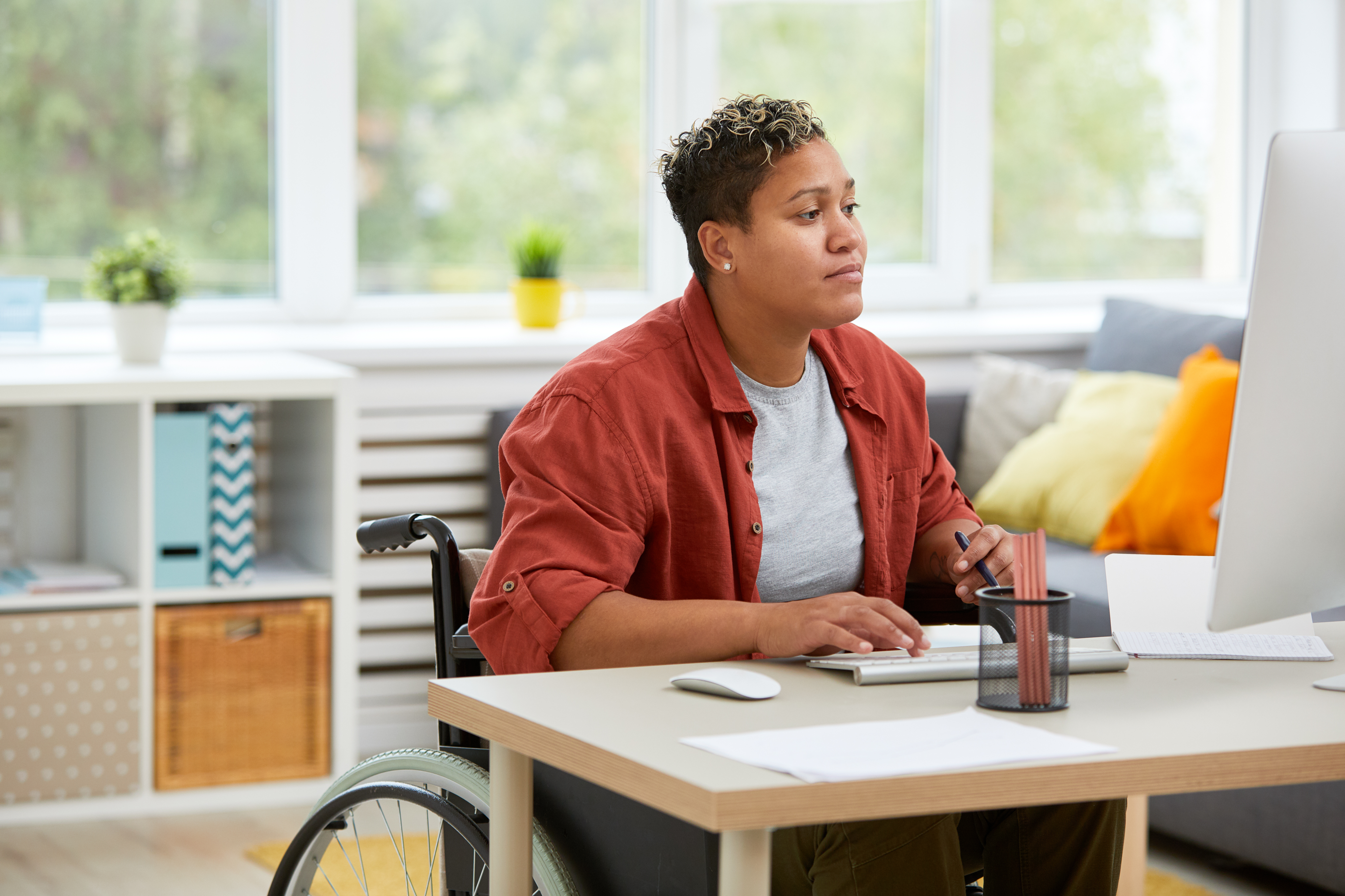 Woman in wheelchair typing on computer