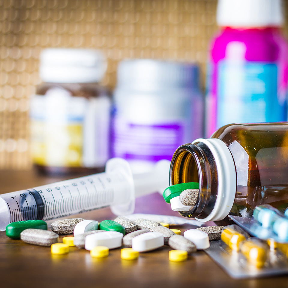 Pills and pill boxes on a wooden desk