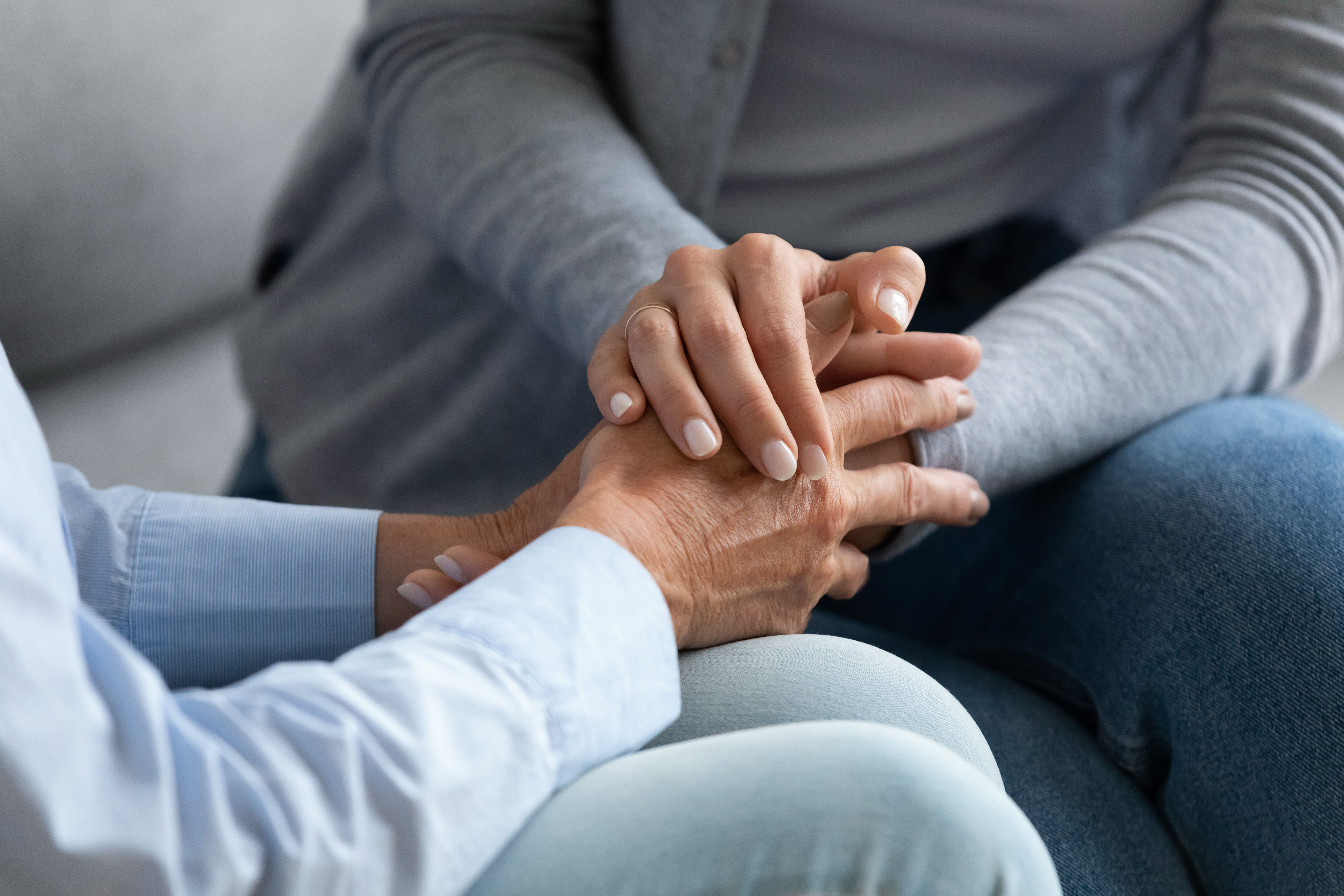 Person comforting another through grief, holding hands