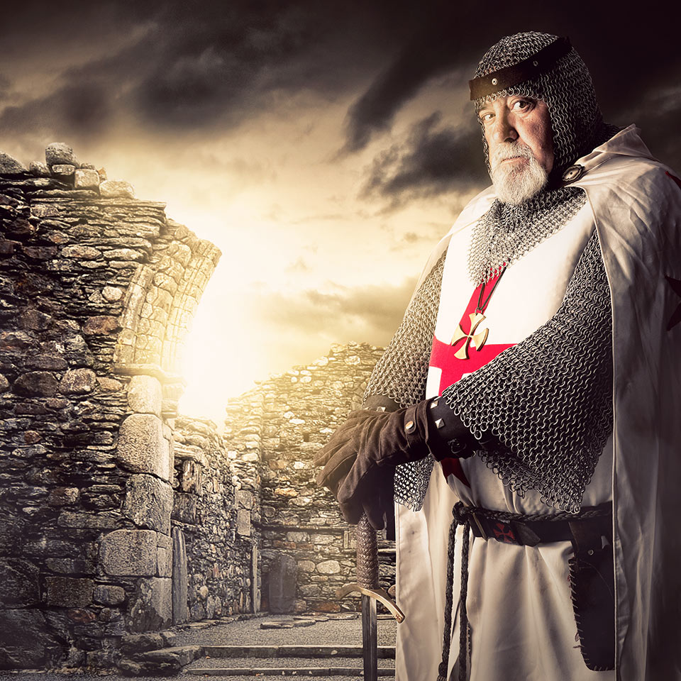 Knight Templar stood in front of sunlit ruins