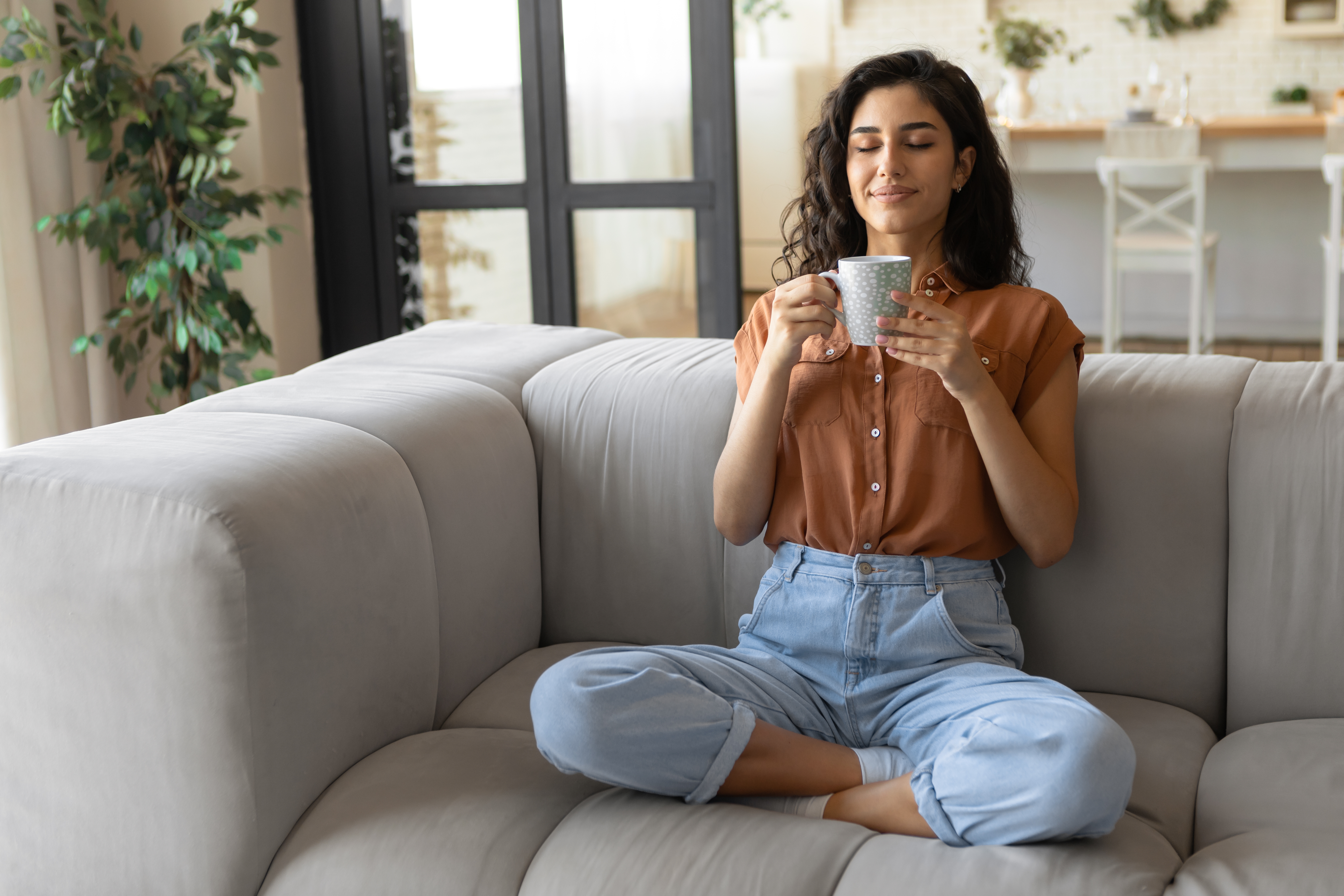 A woman with her eyes closed and a mug of tea 