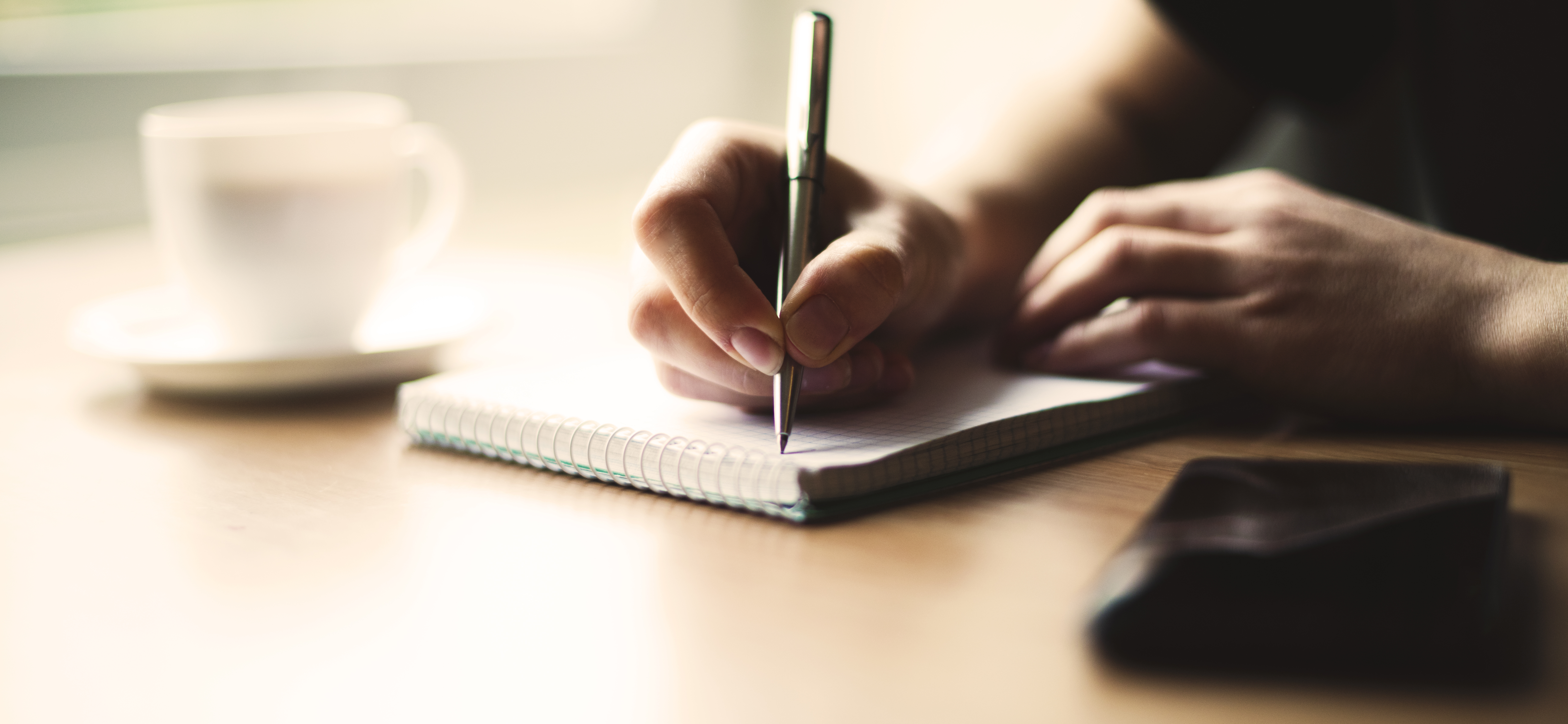 A hand writing in a notepad