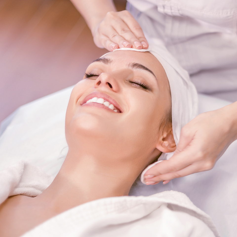 Smiling woman receiving a holistic facial