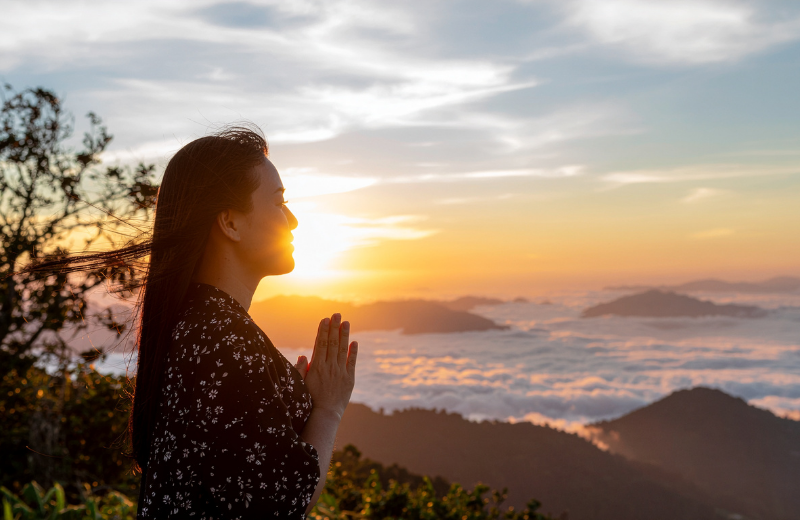 woman praying on mountain
