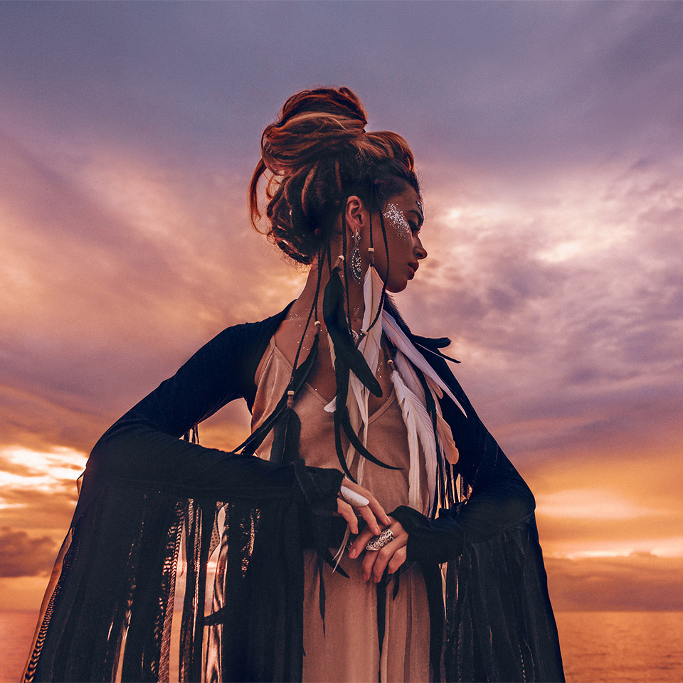 Woman practising sea witchcraft by the ocean.