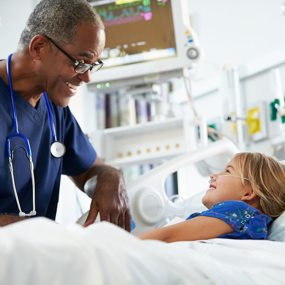 A nurse talking to a young girl in a hospital bed