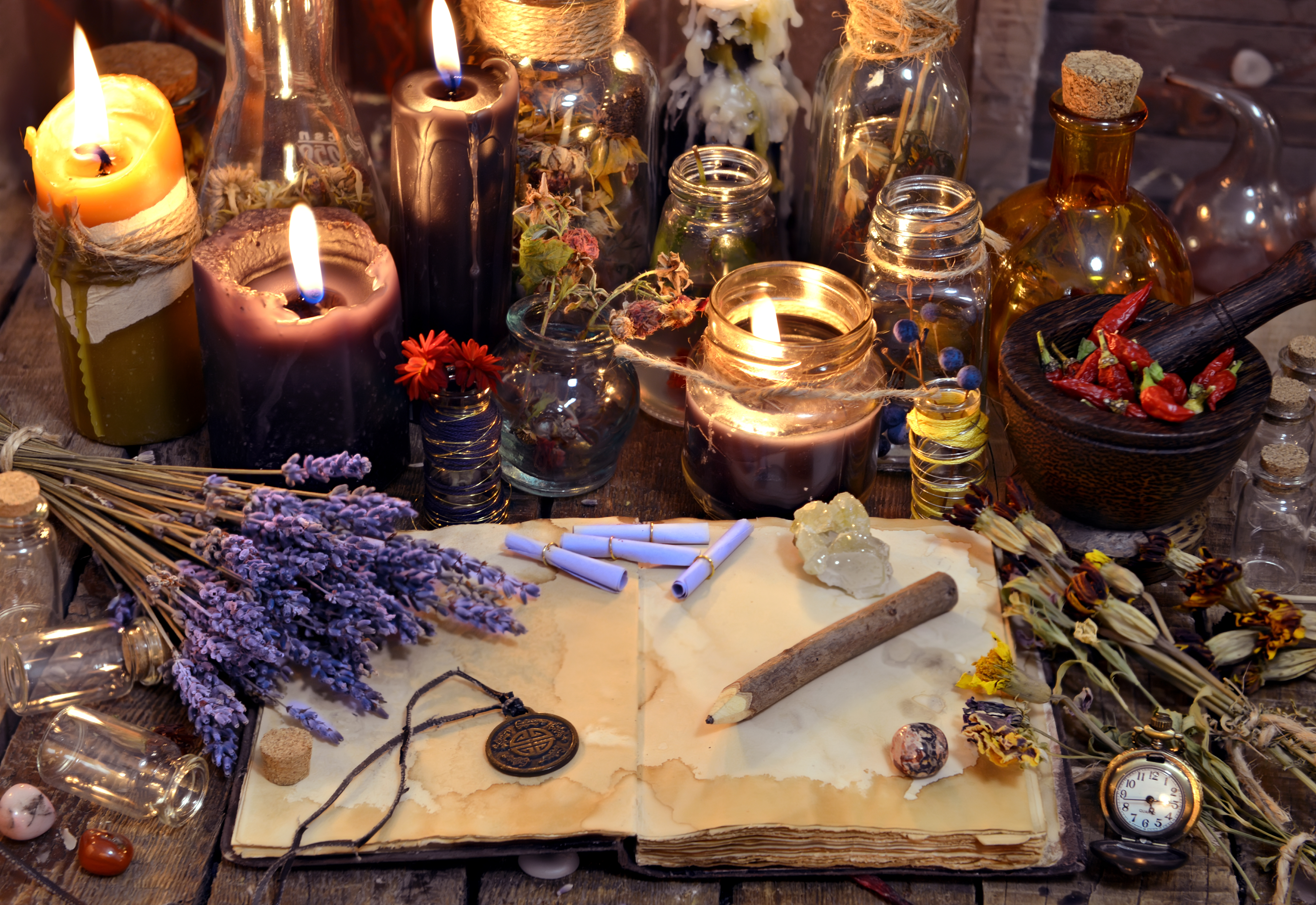 Lit candles, crystals, potions and an open book
