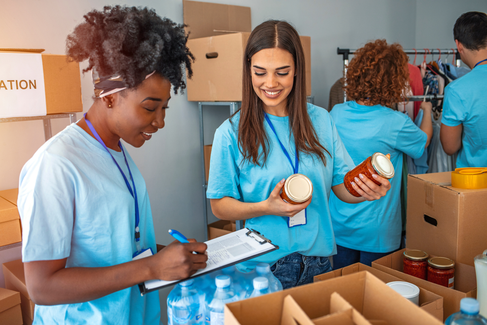 A group of people volunteering, sorting through charity donations