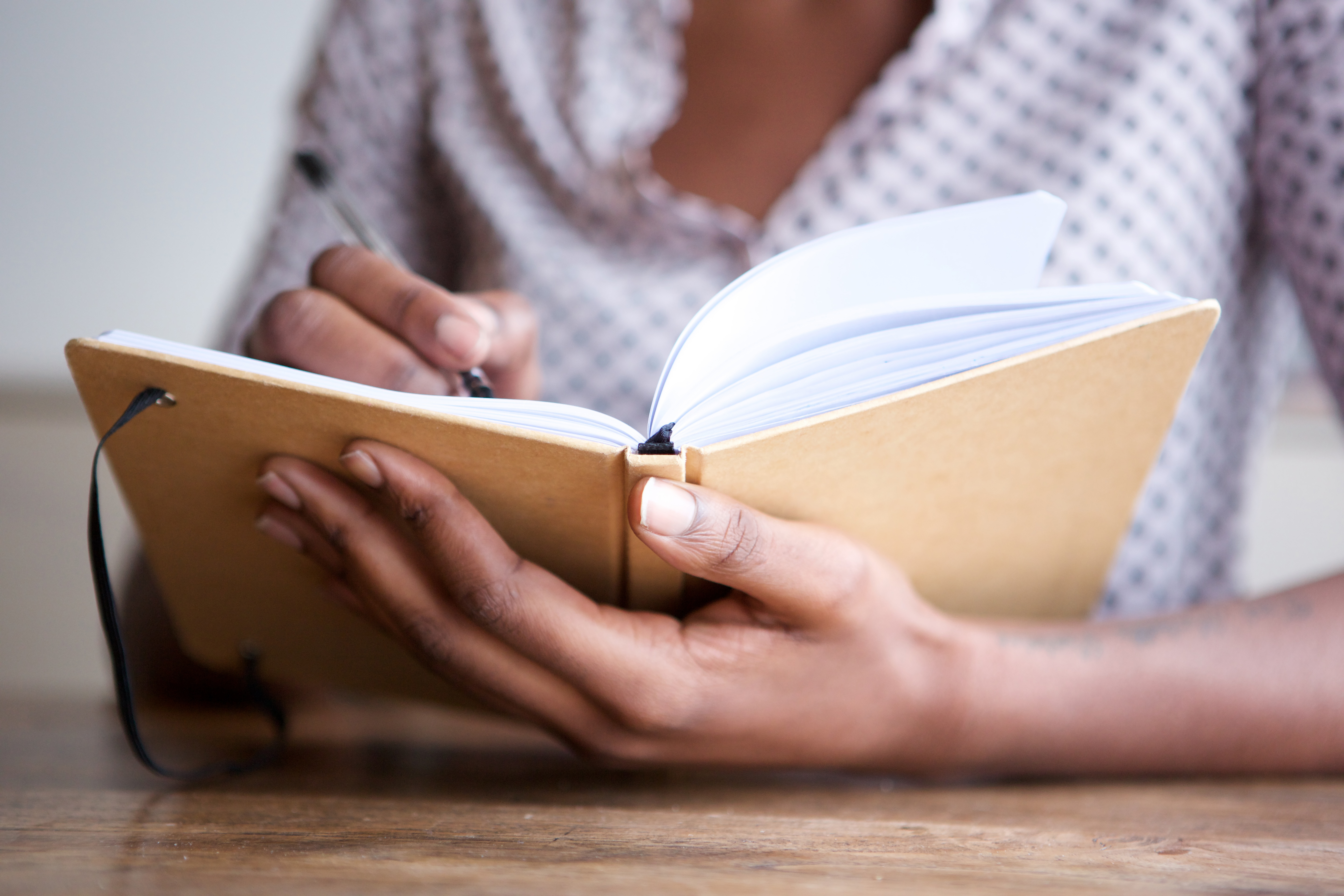 Person journalling pen and paper in notebook