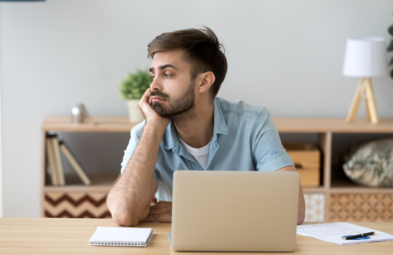 An image of someone looking miserable at work.