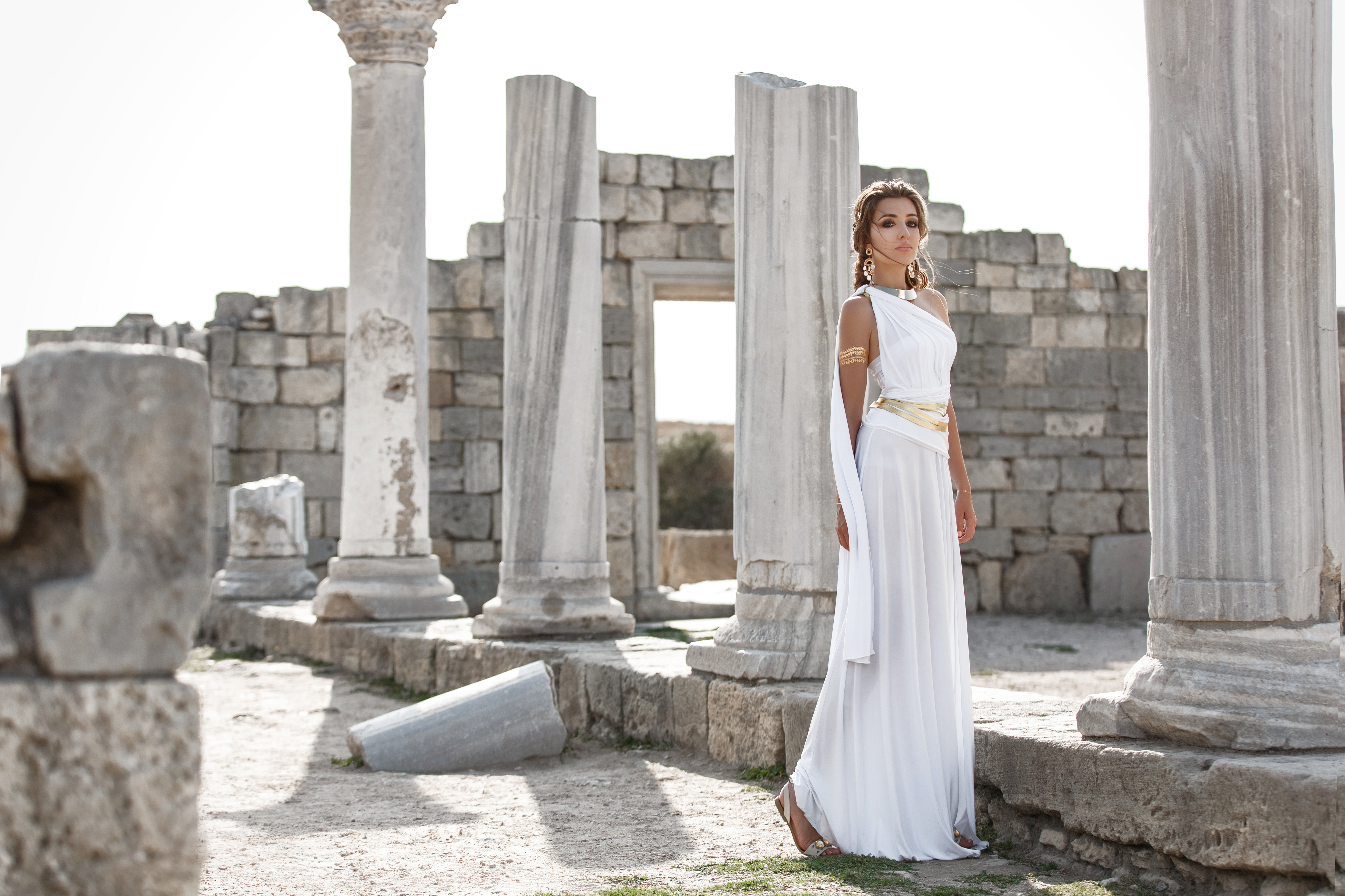 Goddess in a white dress surrounded by ancient ruins