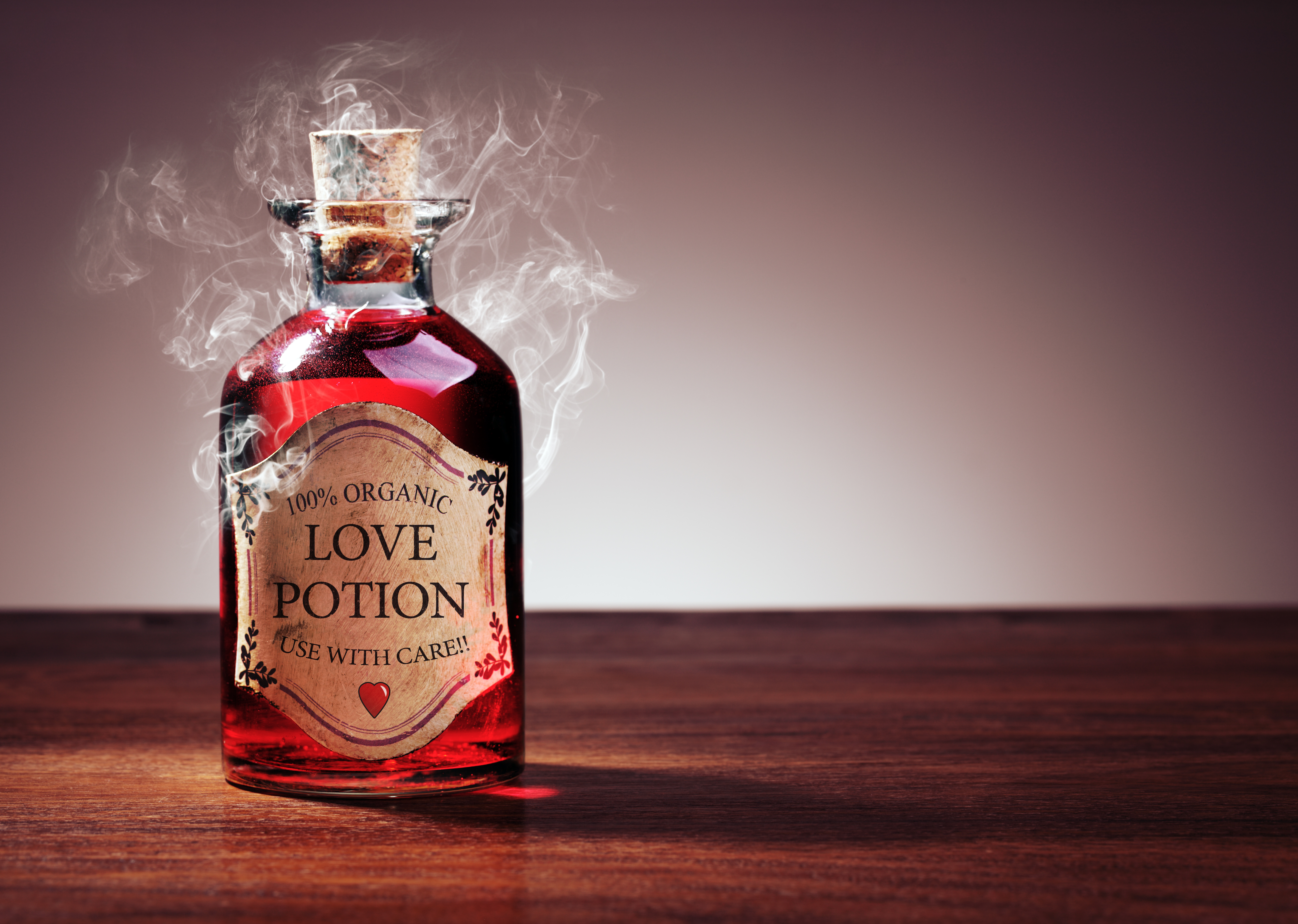 An image of a red liquid in a bottle with love potion written on the label